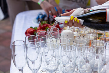 A banquet table with wine glasses and plates with strawberries.