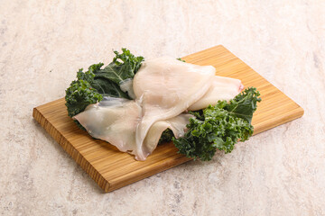 Raw squid over wooden board