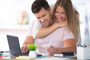 woman embracing boyfriend using computer