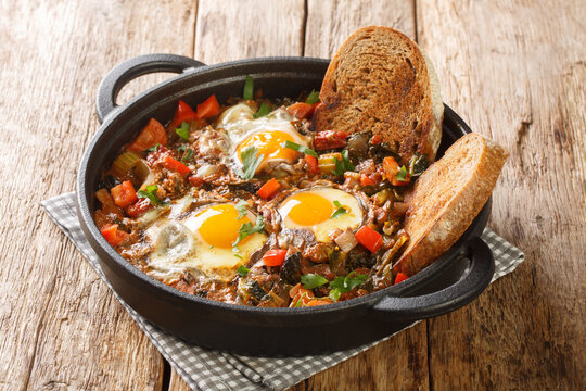 Tasty vegetable soup with eggs Acquacotta served with homemade bread close-up in a bowl on a wooden table. horizontal