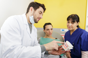young male dentist with patient