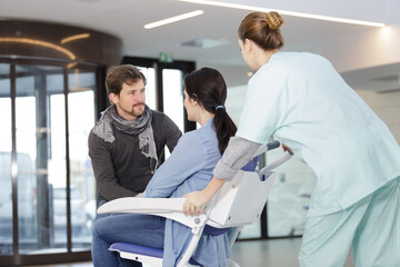 Fototapeta premium husband supporting wife in wheelchair in hospital