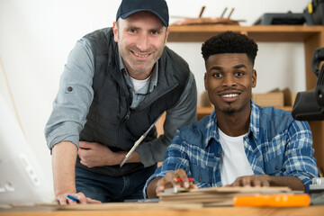 portrait of a happy teacher and apprentice smiling at camera