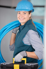 pretty female plumber carrying pipes