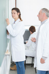 Obraz premium teacher watching student write on chalkboard