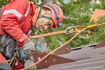 A specialist repairs the roof of the house. Cable car access