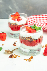 Two Glass of parfait with fresh fruit, yogurt and granola on white table. vertical image. top view. place for text