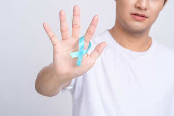 Prostate Cancer Recognition. Close-up of human hand holding blue ribbon light to support life and...
