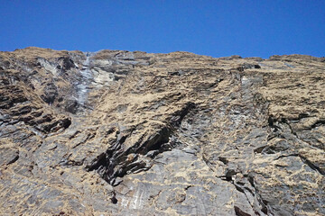 Local Nepali village among natural landscape view of snowcapped mountain cliff and cloudy blue sky- Nepal