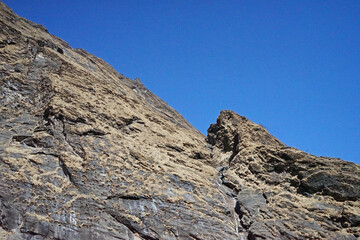 Local Nepali village among natural landscape view of snowcapped mountain cliff and cloudy blue sky- Nepal