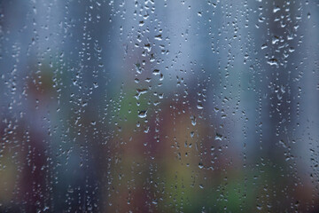 Abstract background with rain drops on window and blurred daylight.