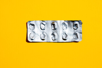 Leere Tabletten Blisterpackung vor gelben Hintergrund, top view
