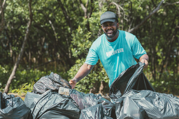 Volunteer man clean up garbage waste in the forest for ecology in Earth day.