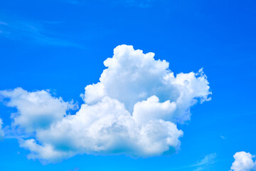 Naklejka na ściany i meble One isolated white cloud in a blue sky. Heaven background. Wallpaper. Beautiful cloudscape. Cumulus clouds. Weather forecast. Outdoor natural landscape. Banner. Dreams. Summer season