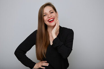 Happy business woman in black holding hands on hip and touching face, isolated female office worker portrait.