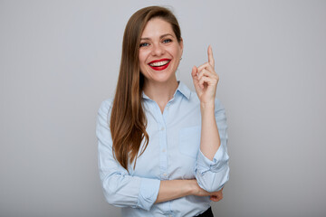 Smiling business woman pointing finger up. Isolated happy female businessman portrait.
