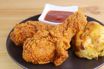 Closeup of Crispy Golden Brown Fried Chicken Drumsticks with Herb Biscuit and Dip