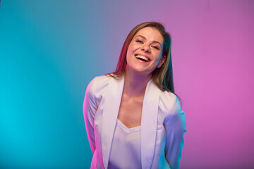 Emotional business woman with open mouth, portrait with neon lights colors effect. Female model on neon colored background wearing white suit.