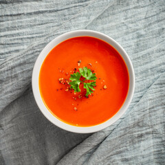 Bowl of tomato soup with parsley top view