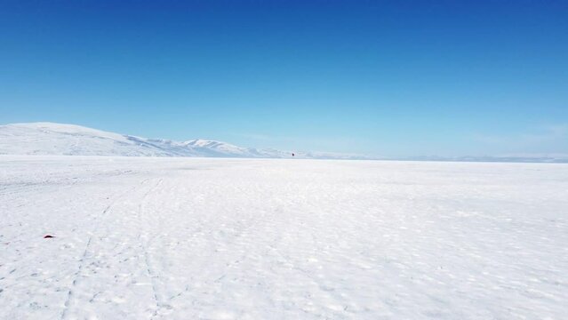 Footage of Flying above the frozen lake Cildir  with a drone at Kars Turkey in winter.