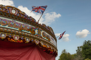 a fairground carousel covered up for winter. with a blue sky and clouds