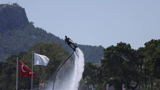 A man on a flyboard entertains vacationing tourists on the Turkish coast in Kemer