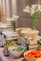 Flower arrangement for summer wedding, made of roses and green branches on a dinner table in the restaurant. , glass and plates in the restaurant outside on a windy day with film grain effect