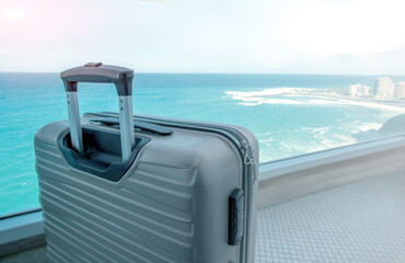 Concept for tropical travel. Suitcase on balcony with ocean view in luxury beach hotel.Copy space