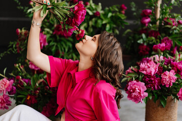 an attractive young woman in a pink blouse with peony flowers