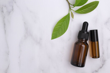 Cosmetic glass bottle with dropper and green leaves on podium. The concept of a beauty salon and natural cosmetics.