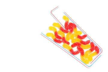Glass of gummy worms isolated on white