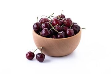 Fresh cherries with water drops in wooden bowl isolated on white background	
