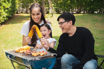 Asian family having a barbecue party at home. Cooking grilled bbq for dinner in backyard. Lifestyle on holiday.