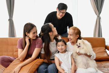 Portrait of happy Asian family with a dog having fun together at home.