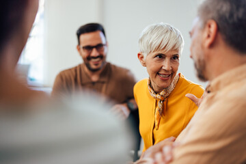 Obraz premium Focused woman, carefully listening and talking to one man during the group therapy.