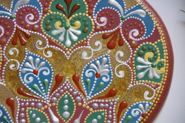 Handpainted pomegranate with intricate ornate pattern, made from wood, painted with acrylic colors. Ornamental design on a red background.