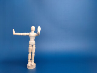 Wooden mannequin with action on a blue background with copy space.