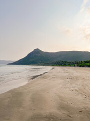 Fototapeta na wymiar coastline against the backdrop of the ocean and green mountains.