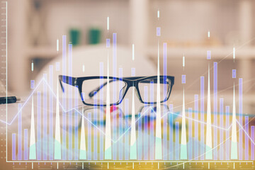 Financial chart hologram with glasses on the table background. Concept of business. Double exposure.