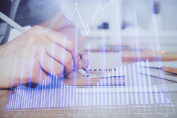 Multi exposure closeup hands with stock market forex graph.