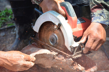 Workers use electric saws to cut wood.