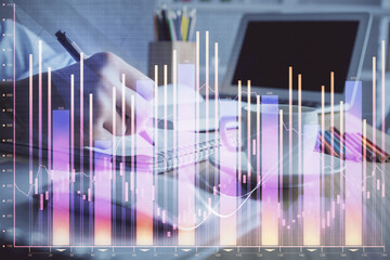 Financial chart drawn over hands taking notes background. Concept of research. Double exposure