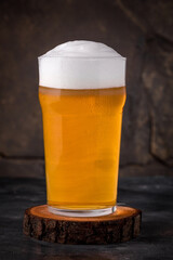 a glass of cold light beer in a mug on a dark background