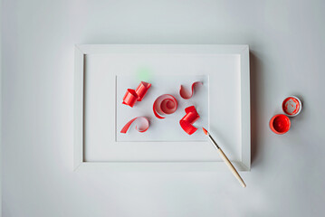A frame with a passe-partout and a levitating brush draws 3D ribbons with red paint.