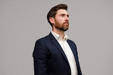 Portrait of handsome serious businessman in suit looking away
