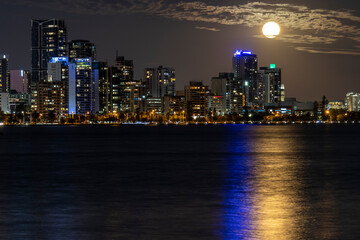 city skyline at night with full moon