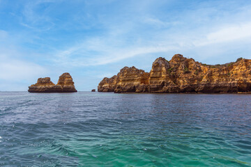 Panoramic view, Ponta da Piedade Lagos in Algarve, Portugal. Cliff rocks,  and tourist boat on sea and caves at Ponta da Piedade, Algarve region, Portugal.