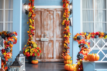House entrance staircase decorated for autumn holidays, fall flowers and pumpkins. Cozy wooden...