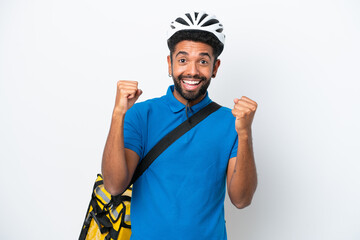 Young Brazilian man with thermal backpack isolated on white background celebrating a victory in winner position