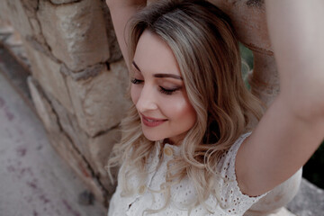 Fototapeta premium Beautiful woman in dress outdoor. Fashion female model walk in the street of old city view